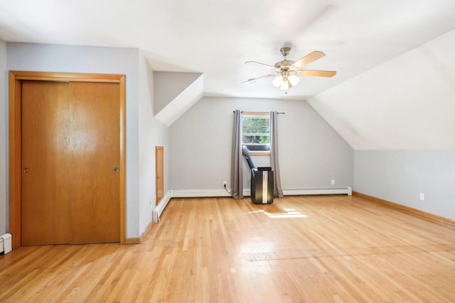 additional living space featuring ceiling fan, a baseboard heating unit, light wood-type flooring, and lofted ceiling