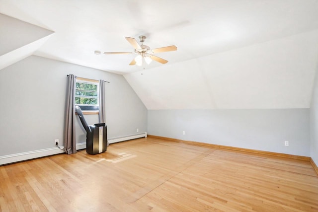 additional living space with ceiling fan, vaulted ceiling, hardwood / wood-style floors, and a baseboard heating unit