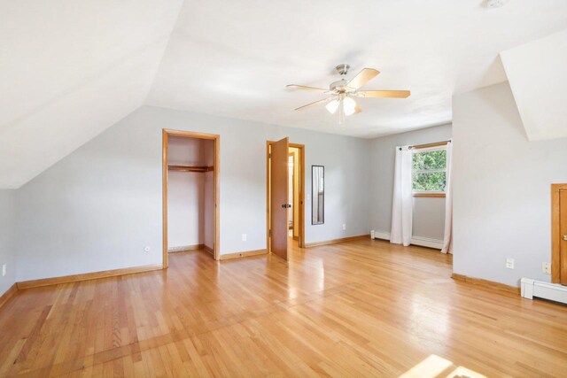 bonus room with ceiling fan, light hardwood / wood-style flooring, vaulted ceiling, and a baseboard heating unit