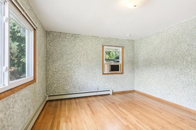 spare room with baseboard heating and hardwood / wood-style flooring