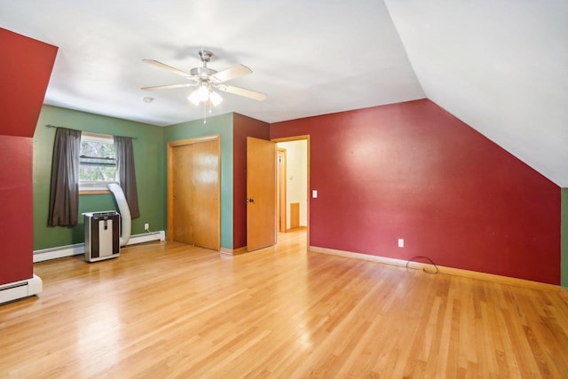 additional living space featuring ceiling fan, light wood-type flooring, a baseboard heating unit, and lofted ceiling