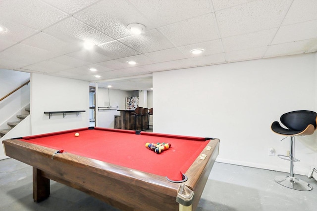 playroom with pool table, a paneled ceiling, and concrete floors