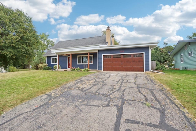 view of front of home with a garage, central AC, and a front yard