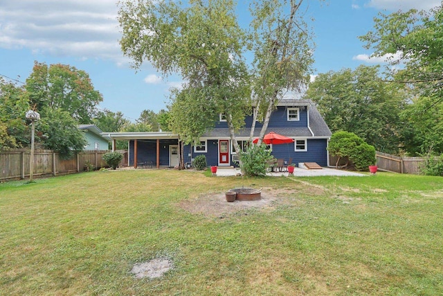 back of property with a lawn, an outdoor fire pit, and a patio area