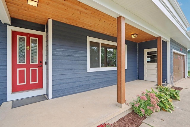 doorway to property with a porch and a garage