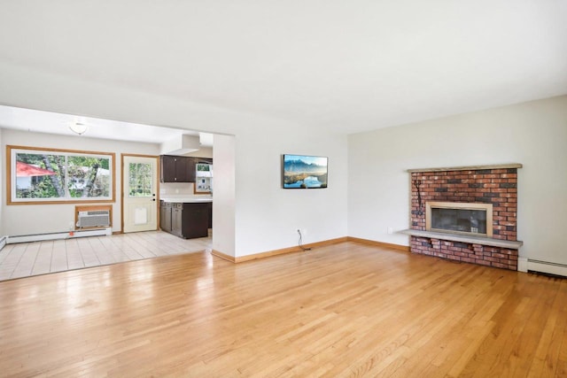 unfurnished living room featuring a fireplace, baseboard heating, light hardwood / wood-style flooring, and a wall mounted air conditioner