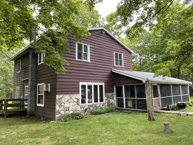 back of property featuring a sunroom and a yard