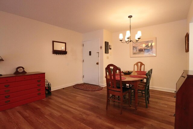 dining area featuring dark wood-type flooring and a notable chandelier