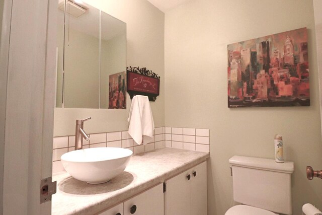bathroom with tasteful backsplash, vanity, and toilet