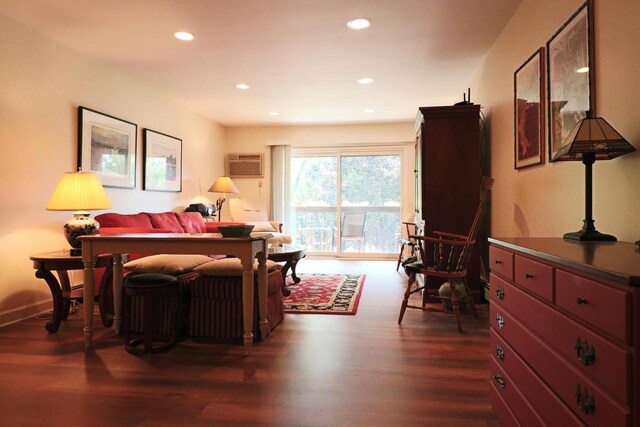 living room featuring a wall mounted air conditioner and dark hardwood / wood-style floors