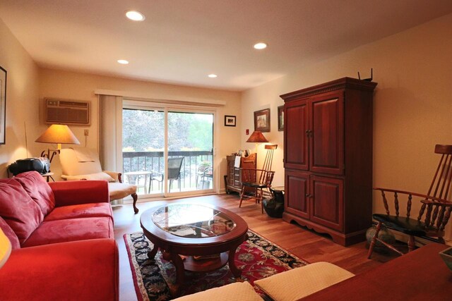 living room featuring an AC wall unit and wood-type flooring