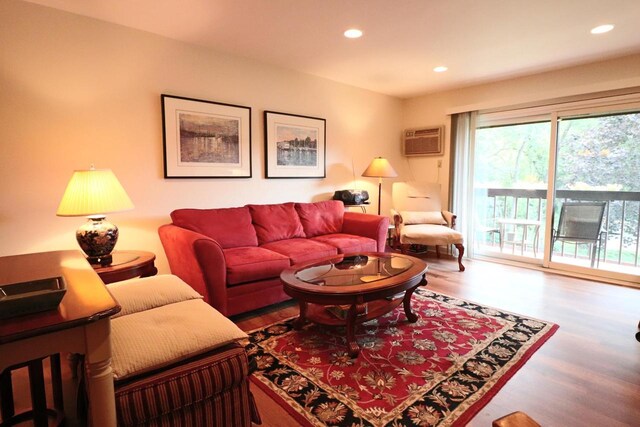 living room featuring hardwood / wood-style flooring and an AC wall unit