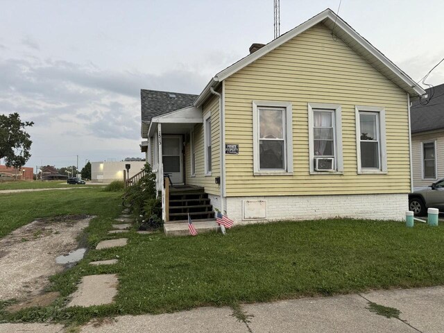 view of front of property with a front lawn and cooling unit