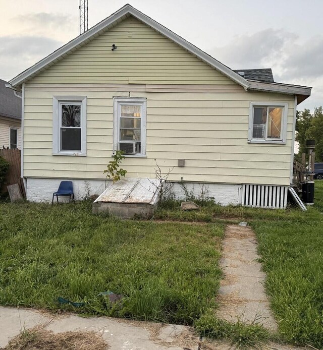 view of home's exterior with cooling unit and a yard