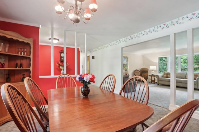 dining area with ornamental molding, a chandelier, and carpet floors