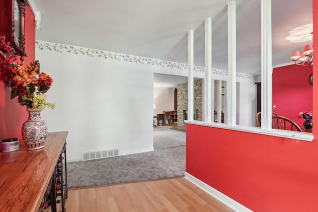 hall with an inviting chandelier and wood-type flooring