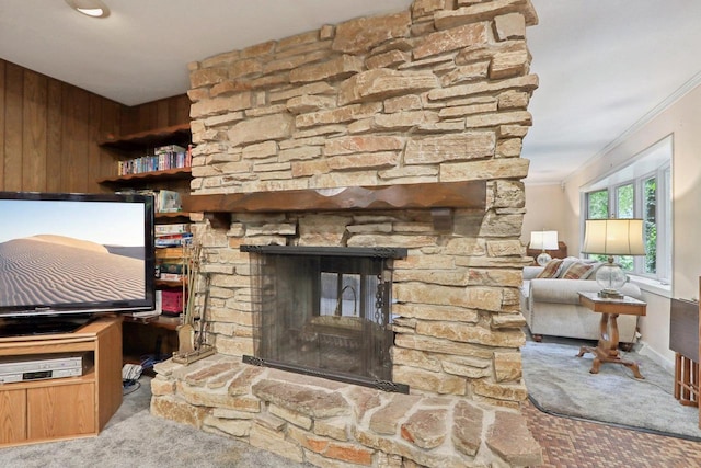 unfurnished living room with light carpet, crown molding, wood walls, and a stone fireplace