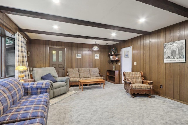 carpeted living room featuring wooden walls and beam ceiling