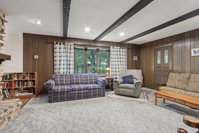 carpeted living room featuring beamed ceiling and wooden walls