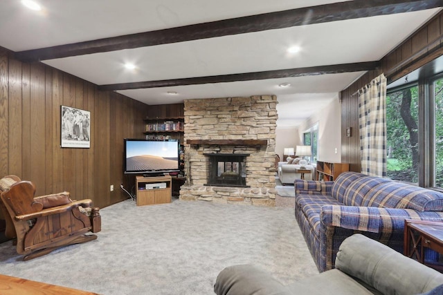 carpeted living room featuring a fireplace, beamed ceiling, and wooden walls