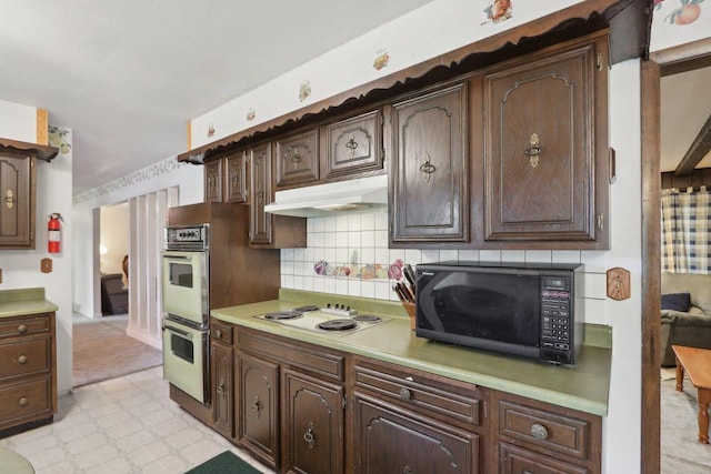 kitchen featuring white electric stovetop, dark brown cabinetry, and double wall oven