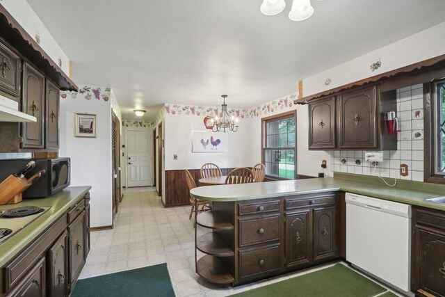 kitchen with a chandelier, white dishwasher, kitchen peninsula, hanging light fixtures, and dark brown cabinetry