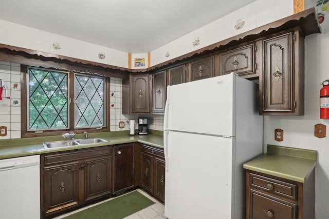 kitchen with white appliances, dark brown cabinets, sink, and backsplash