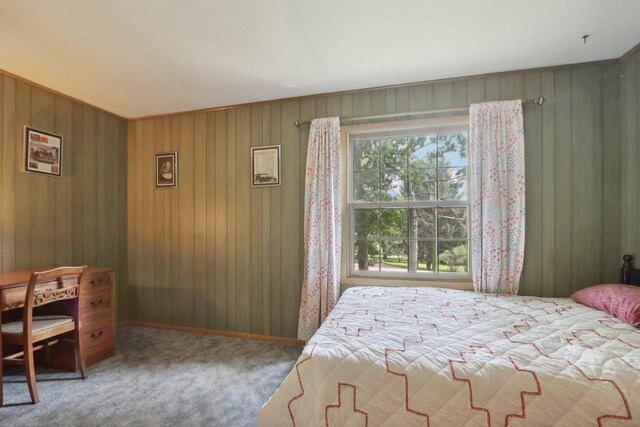 bedroom with wooden walls and carpet flooring