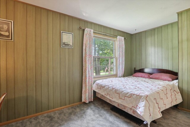 carpeted bedroom with wooden walls