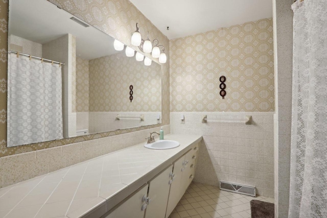 bathroom with tile walls, tile patterned flooring, and vanity