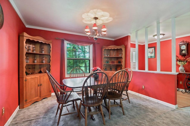 dining area featuring crown molding, carpet, and an inviting chandelier