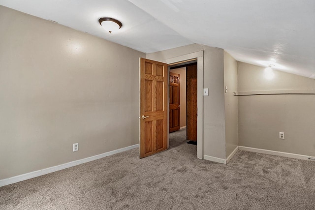 unfurnished bedroom featuring light carpet and vaulted ceiling