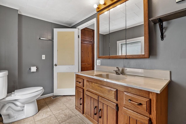 bathroom with tile patterned flooring, toilet, vanity, and ornamental molding