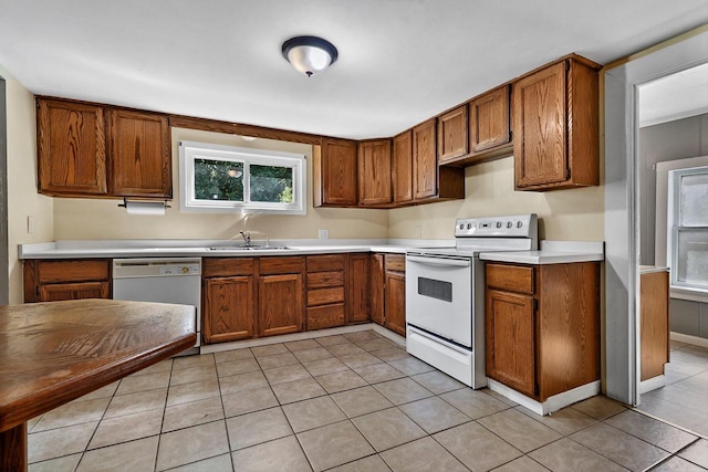 kitchen featuring light tile patterned flooring, sink, and white appliances