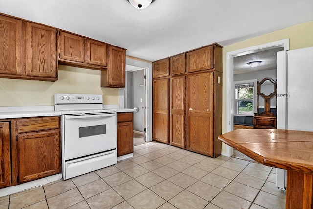 kitchen with white appliances and light tile patterned floors