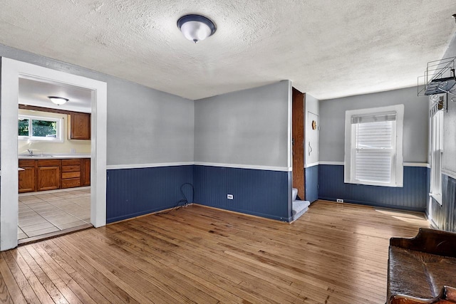 unfurnished room with a textured ceiling and light hardwood / wood-style flooring