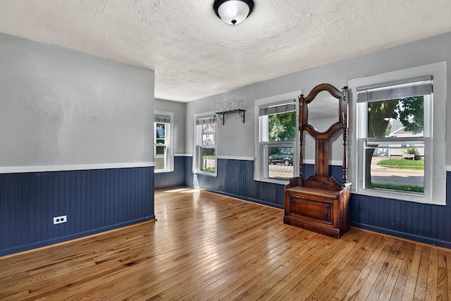 interior space with a textured ceiling and hardwood / wood-style flooring