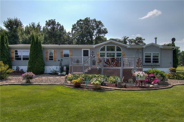 back of property with a yard and a wooden deck