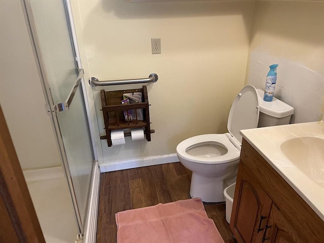 bathroom featuring an enclosed shower, vanity, hardwood / wood-style floors, and toilet