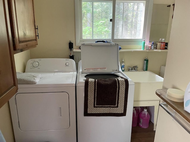 washroom with hardwood / wood-style floors, sink, independent washer and dryer, and cabinets