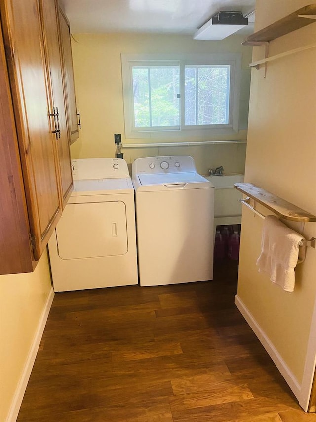 laundry room featuring independent washer and dryer, sink, cabinets, and dark wood-type flooring