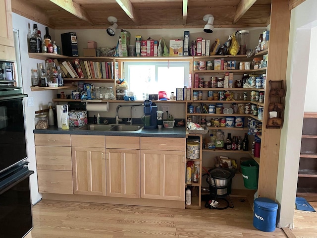 interior space with sink, light wood-type flooring, light brown cabinets, and wood ceiling