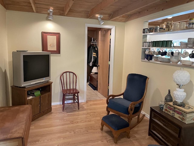 sitting room featuring wooden ceiling, light tile patterned floors, and beamed ceiling