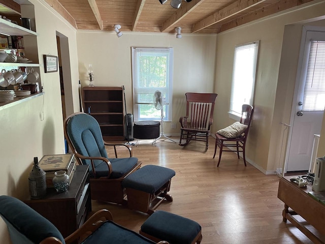 sitting room featuring light wood-type flooring, beamed ceiling, and wooden ceiling