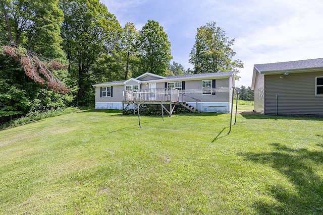 back of property featuring a wooden deck and a yard