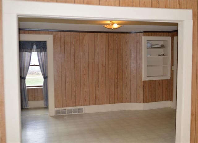 additional living space with vaulted ceiling, wooden walls, and light colored carpet