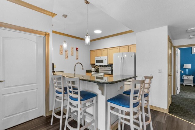 kitchen featuring a breakfast bar, backsplash, white appliances, dark carpet, and light brown cabinets