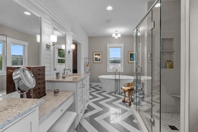 bathroom with tile patterned flooring, independent shower and bath, and vanity