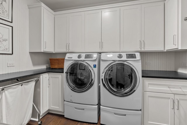 laundry area with dark hardwood / wood-style flooring, independent washer and dryer, and cabinets