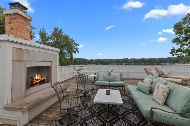 deck with outdoor lounge area and a water view